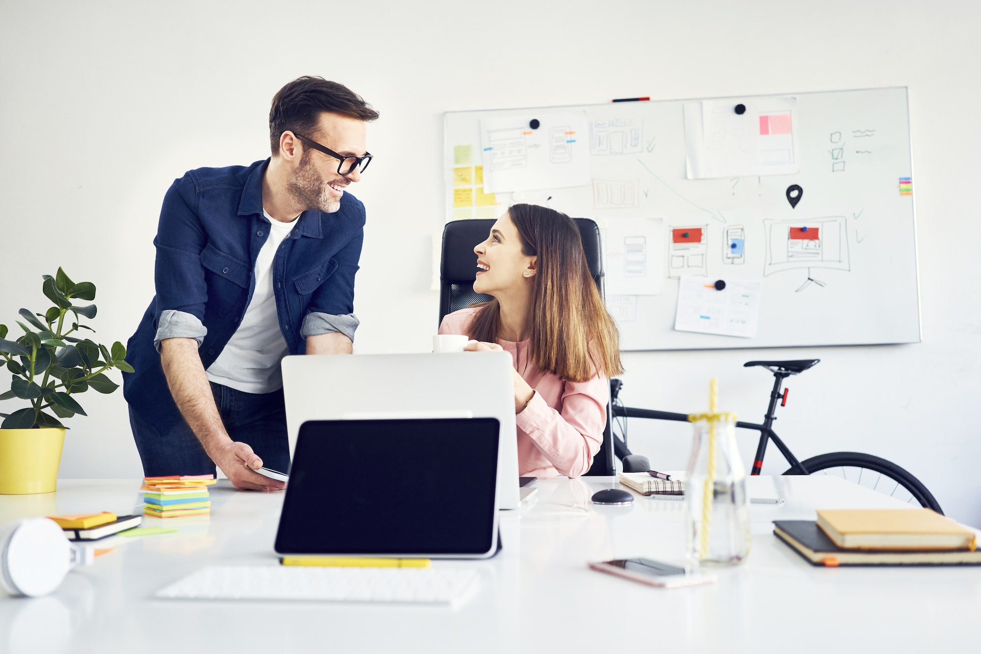 Two colleagues working together on laptop in office